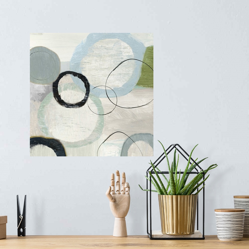 A bohemian room featuring An abstract painting of circles in varies sizes and colors.