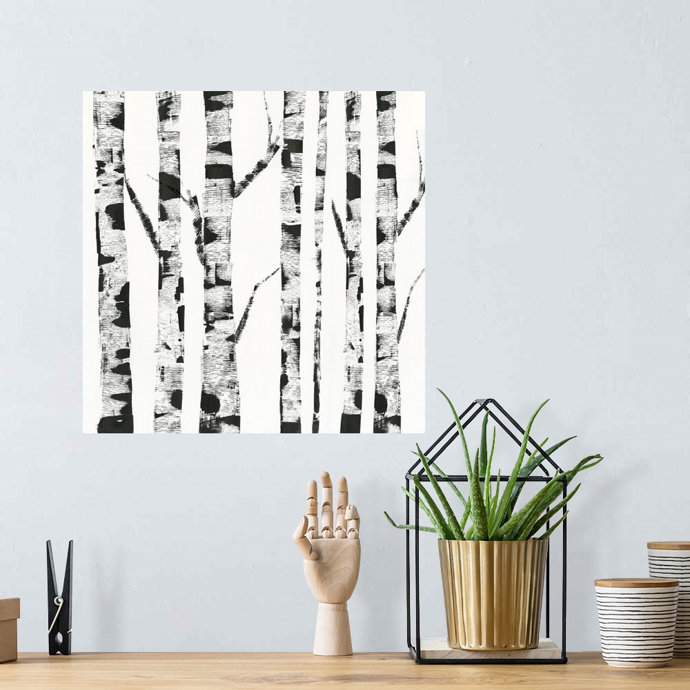 A bohemian room featuring White and black artwork of birch trunks.