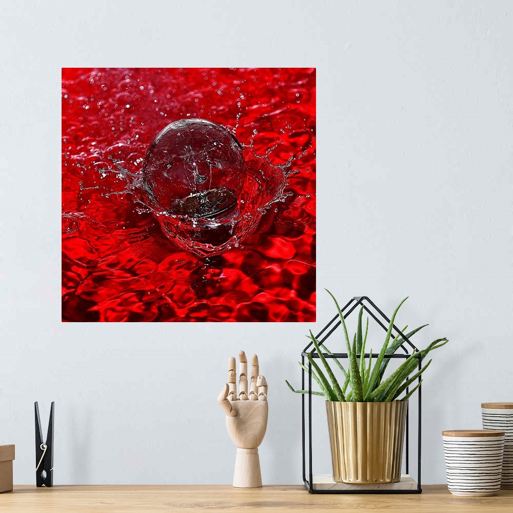 A bohemian room featuring Macro photograph of a water drop splashing into water reflecting bright red.