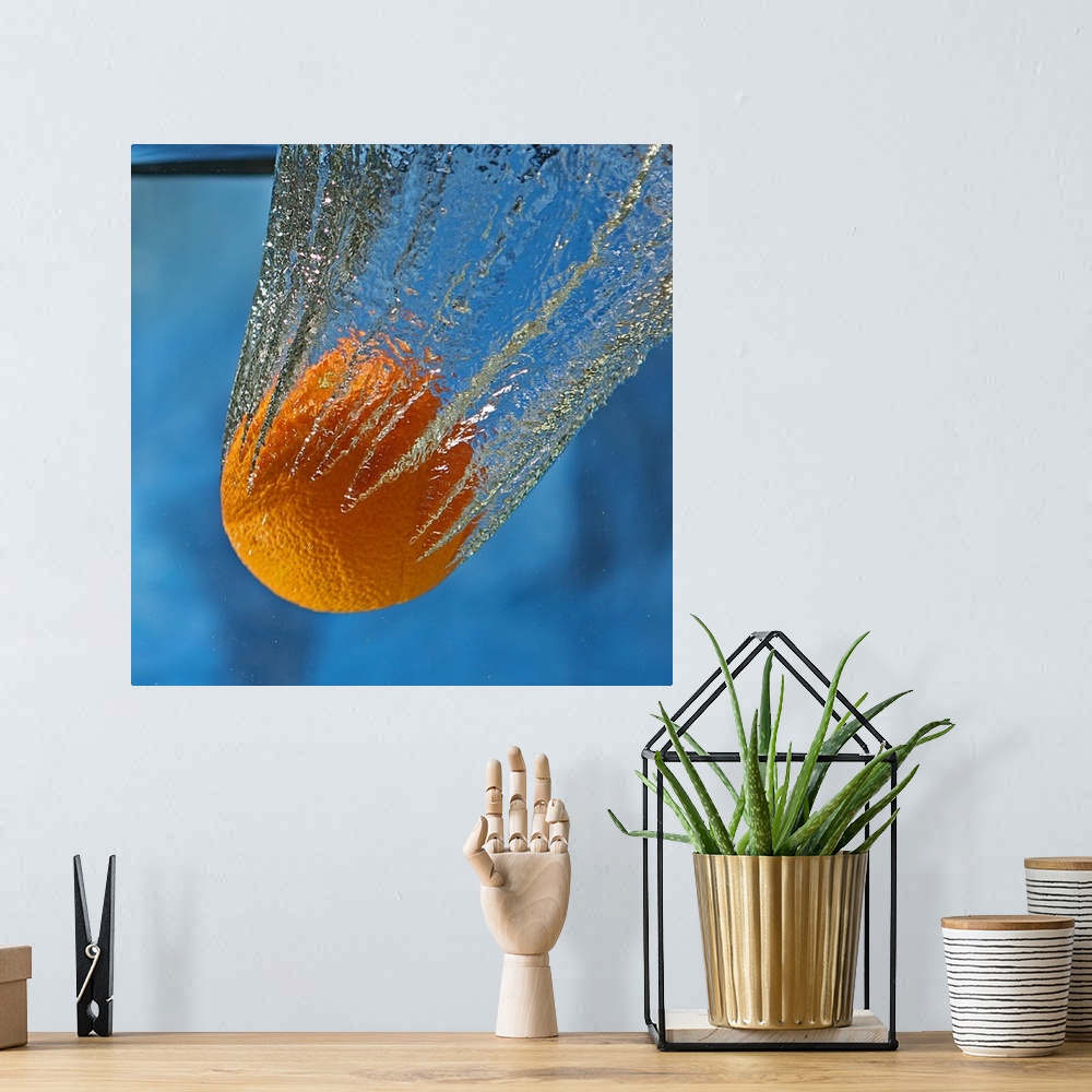 A bohemian room featuring An orange splashing into a tank of clear water.