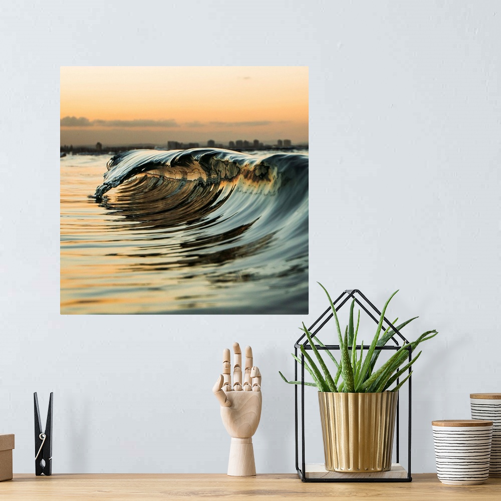 A bohemian room featuring A "mini" wave off the coast at sunset.