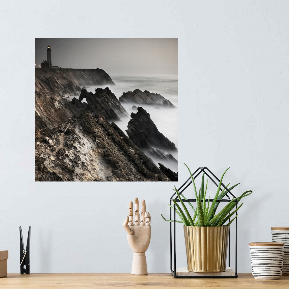 A bohemian room featuring Dynamic photograph of a lighthouse on a foggy jagged rocky coast.