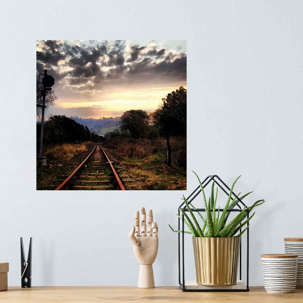 A bohemian room featuring Railway line leading into the setting sun, beautiful dramatic sky.