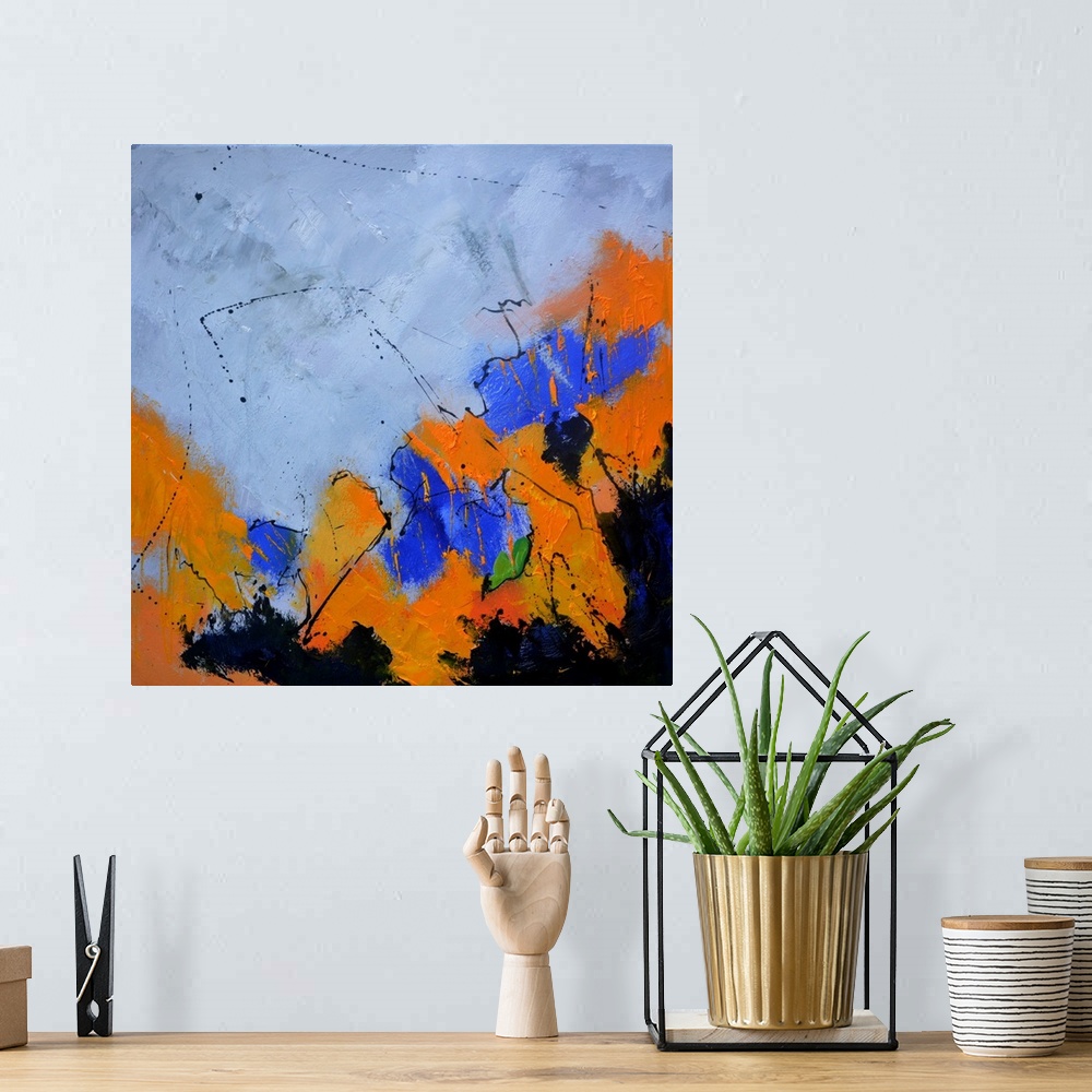 A bohemian room featuring A square abstract painting in dark shades of black, blue and orange with splatters of paint overl...