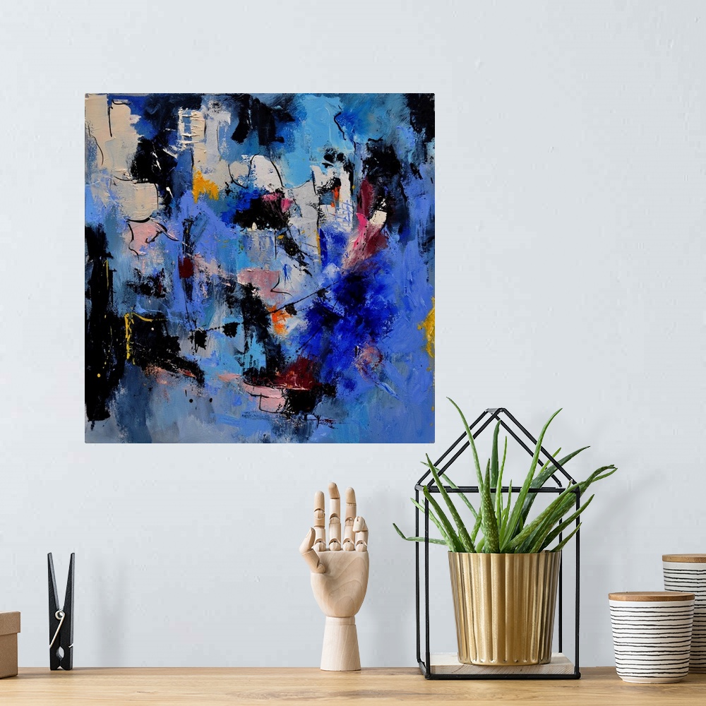 A bohemian room featuring A square abstract painting in dark shades of black, blue, white and pink with splatters of paint ...