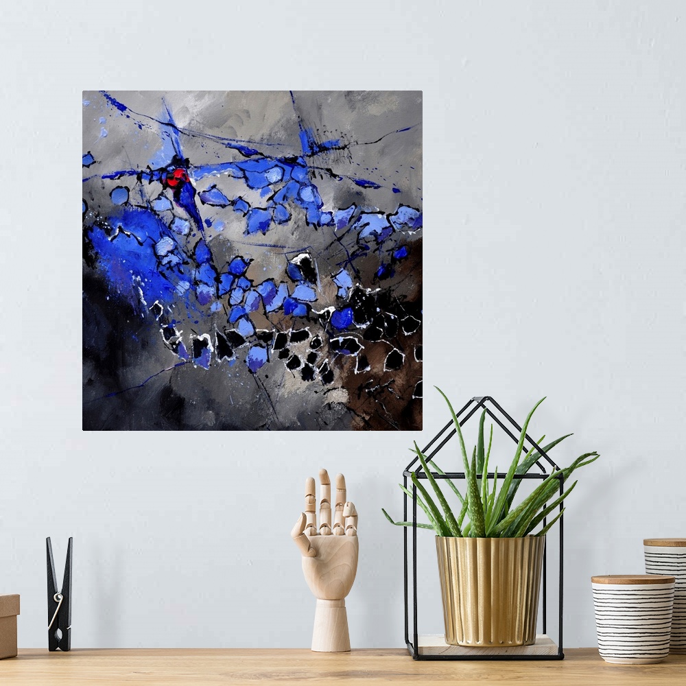 A bohemian room featuring A square abstract painting in dark shades of black, blue, white and red with splatters of paint o...