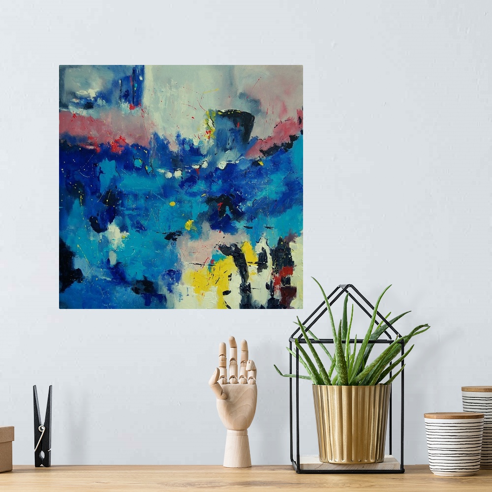 A bohemian room featuring A square abstract painting of colors of red, yellow and blue in textured brush strokes and splatt...