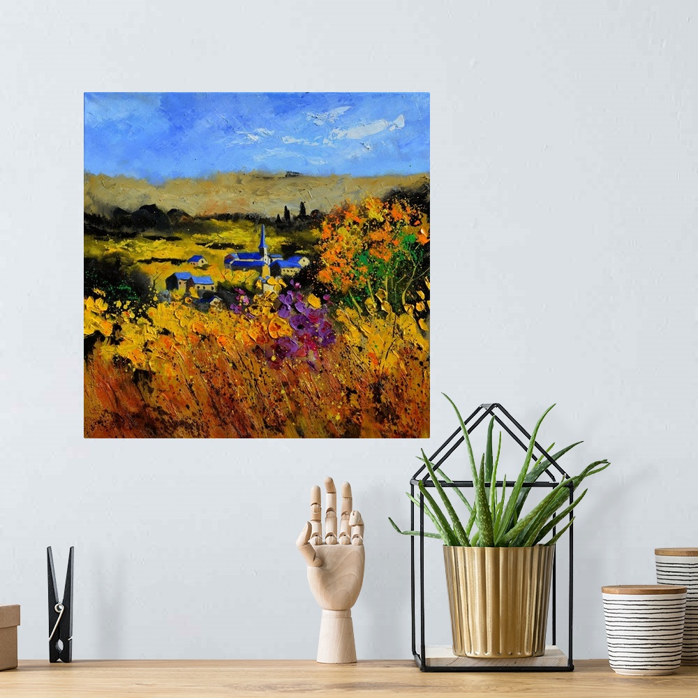 A bohemian room featuring Square painting of a field with flowers in the foreground and a Belgium village in the background...