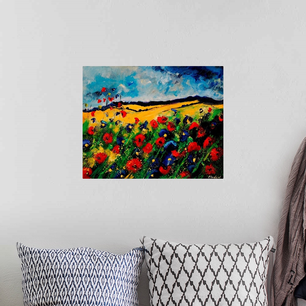 A bohemian room featuring Horizontal painting of a colorful landscape with red and blue poppies in the foreground and rolli...