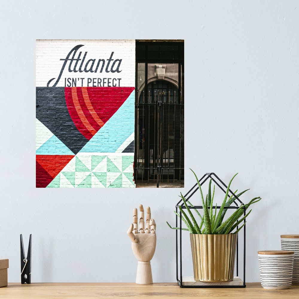 A bohemian room featuring Atlanta Isn't Perfect, geometric mural featuring a quote by Ryan Gravel, on the side of Switchyar...