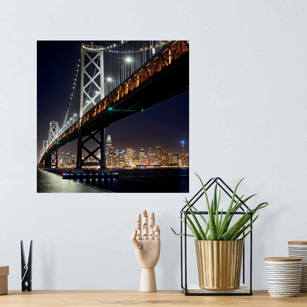 A bohemian room featuring Square photograph of the Bay Bridge lit up at night with the San Francisco skyline in the backgro...