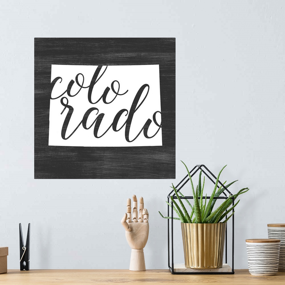 A bohemian room featuring Colorado state outline typography artwork.