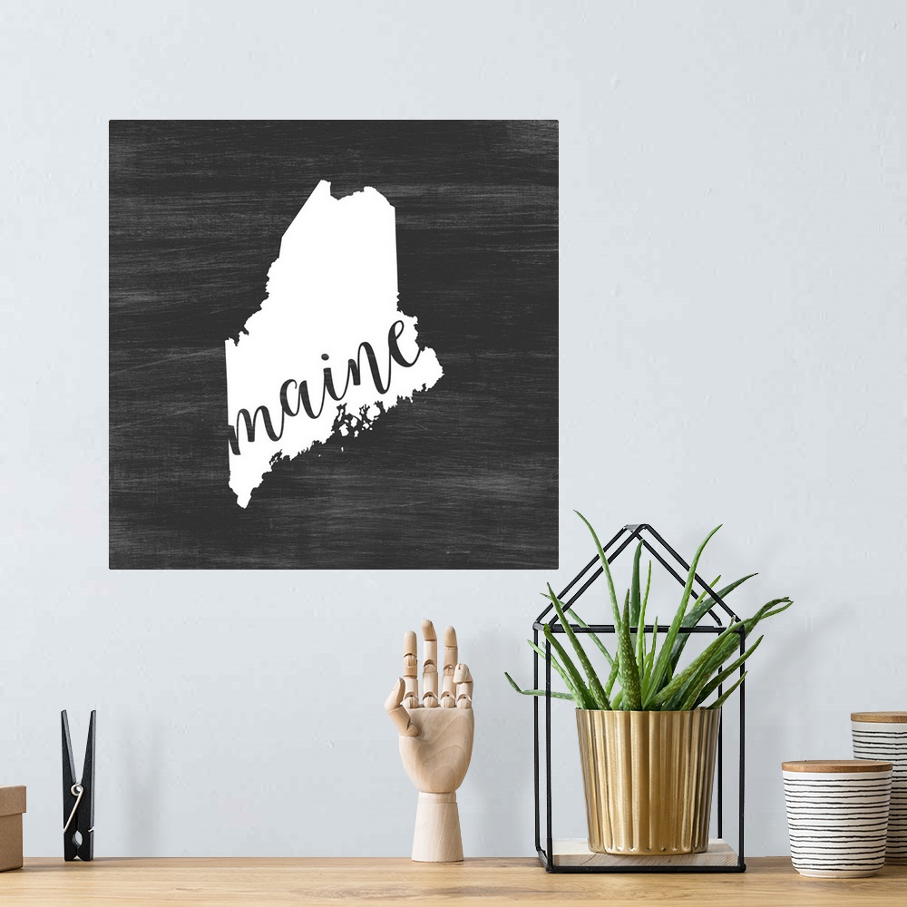 A bohemian room featuring Maine state outline typography artwork.