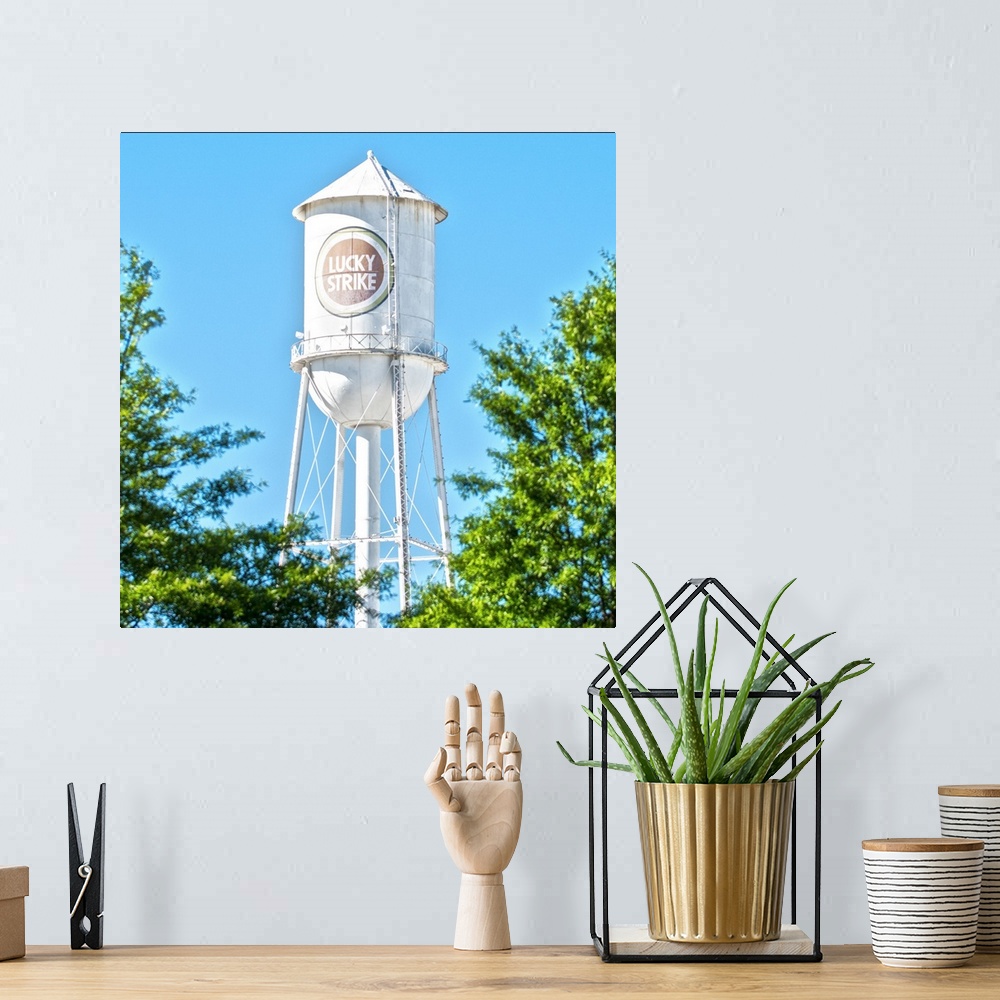 A bohemian room featuring Lucky Strike Water Tower over the trees, with a blue sky behind, American Tobacco Historic Distri...