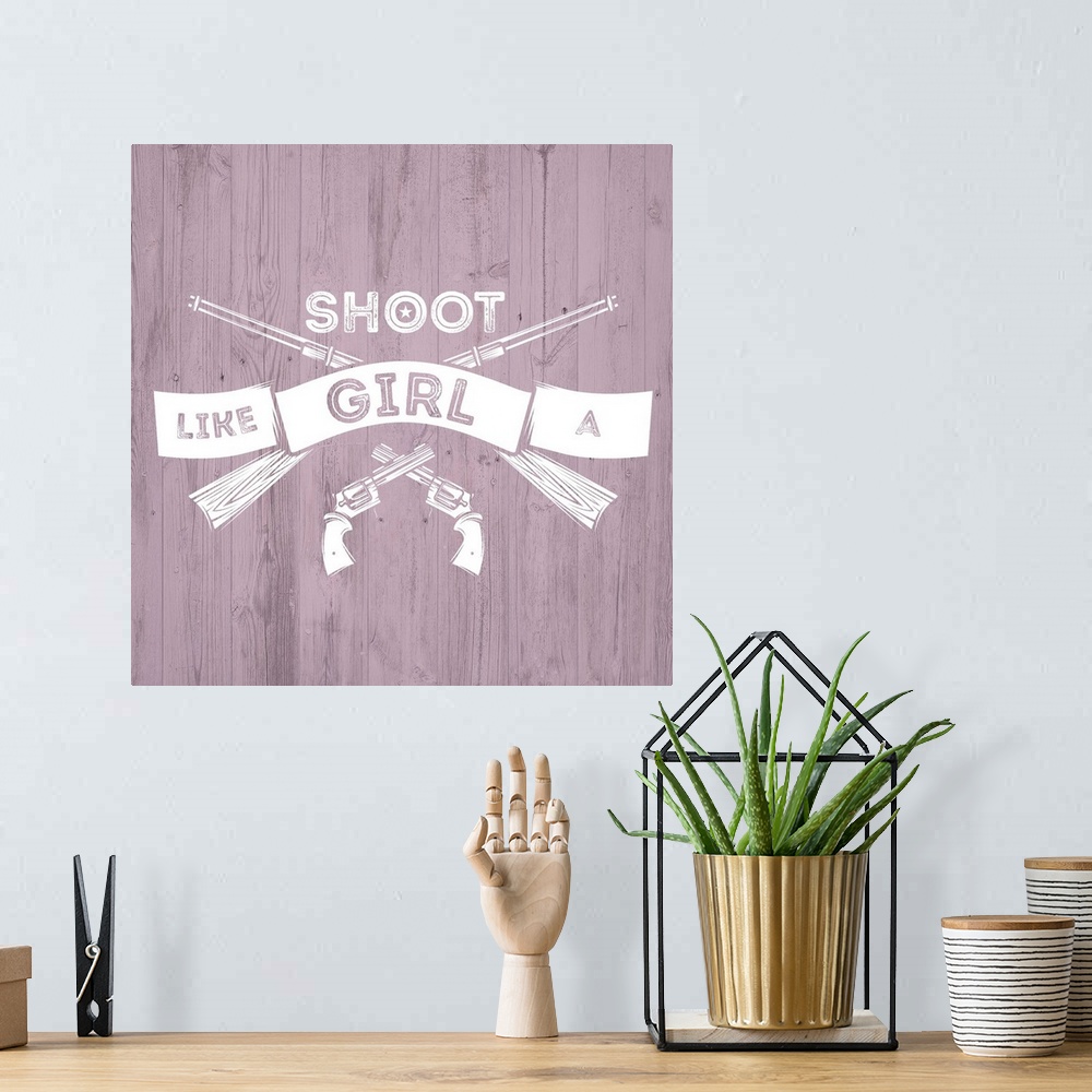 A bohemian room featuring Crossed pistols and rifles with a banner reading "Shoot Like A Girl" on a pink distressed wood ba...