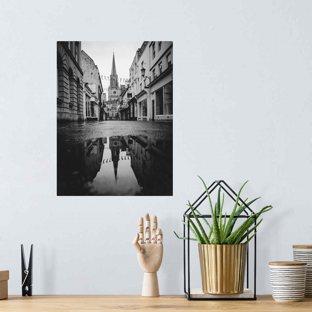 A bohemian room featuring Black and white photograph of St. Michael's Church reflecting into a puddle in the middle of a st...