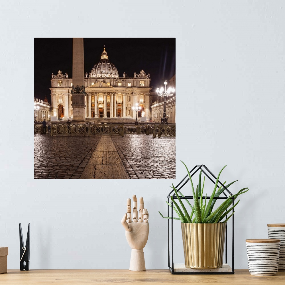 A bohemian room featuring Square photograph of St. Peter's Basilica  lit up at night.