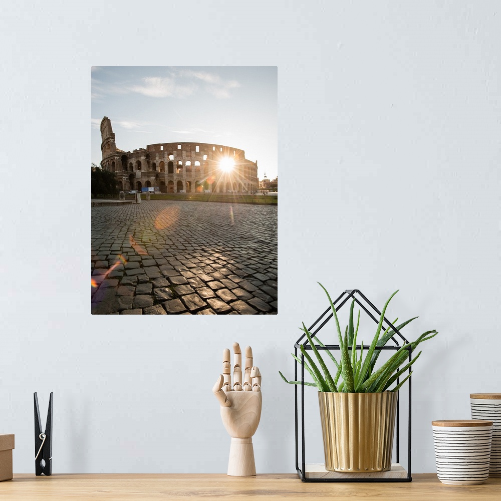 A bohemian room featuring Photograph of the sun shining right though the middle of the Colosseum.