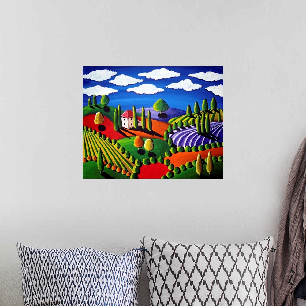 A bohemian room featuring Colorful painting of rolling hills and trees with a single house and white, fluffy clouds above.