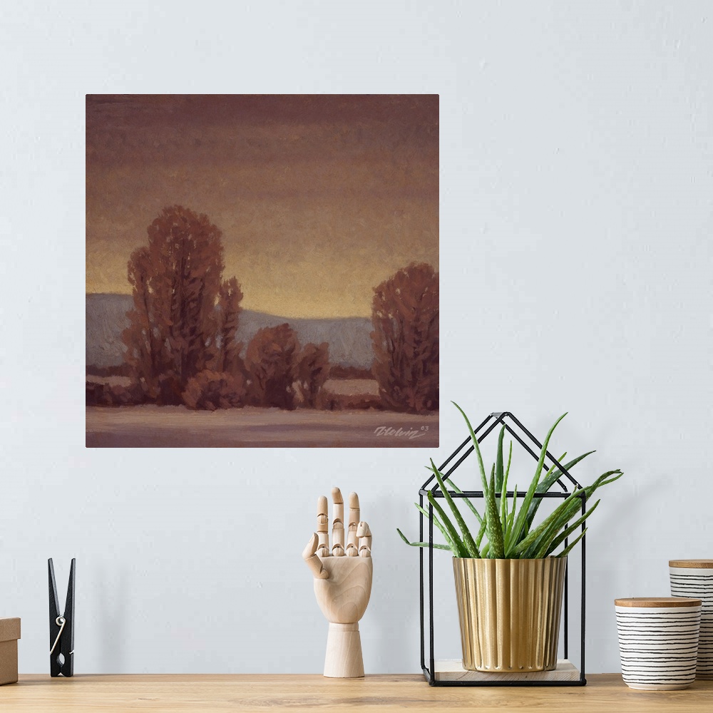 A bohemian room featuring Landscape painting of trees in a tonalist winter setting.