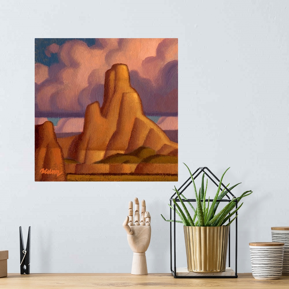 A bohemian room featuring Square landscape painting of large canyons with pink fluffy clouds above.