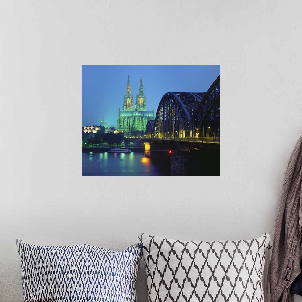 A bohemian room featuring Hohenzollernbrucke and the Cathedral Illuminated at Night, Cologne, Germany.