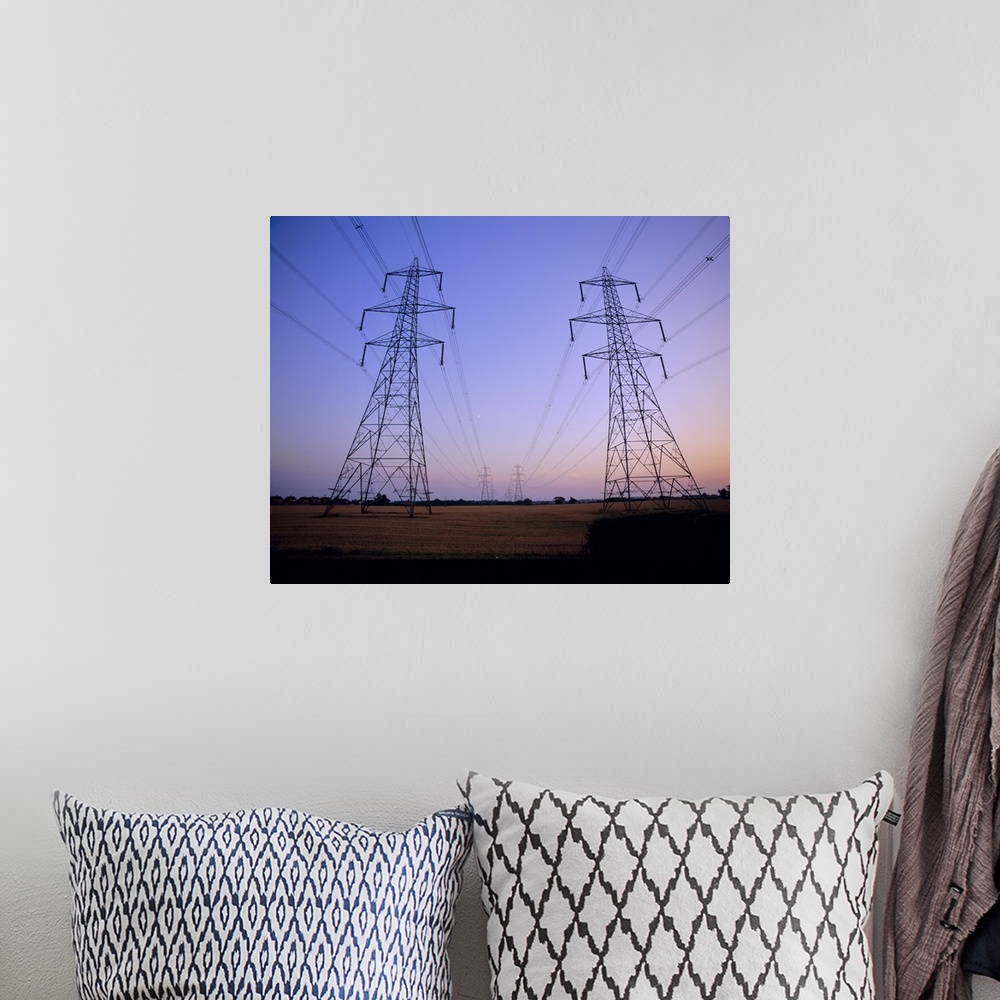 A bohemian room featuring Pylons in a rural landscape at dusk