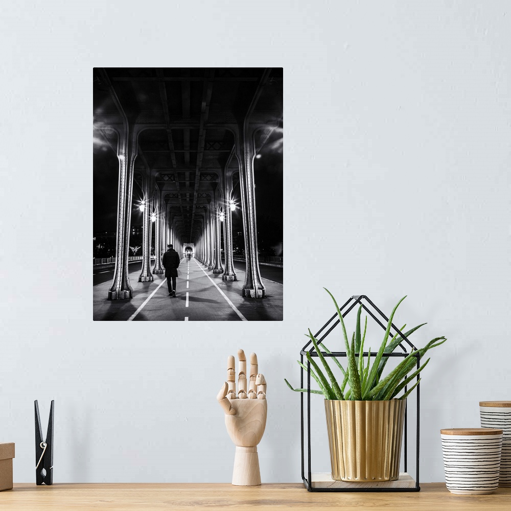A bohemian room featuring Black and white photograph of a man walking under an overpass in Paris.