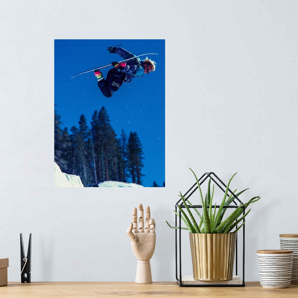 A bohemian room featuring Damian Sanders grabs his snowboard in the air in June Mountain, June Lake, California.
