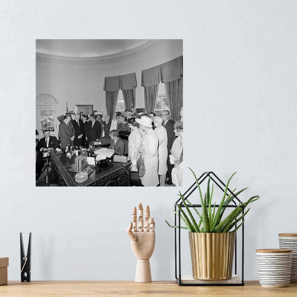 A bohemian room featuring President John F. Kennedy signing the Equal Pay Act.