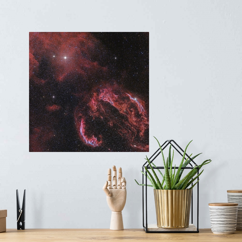 A bohemian room featuring The Veil Nebula in the constellation Cygnus glows red.
