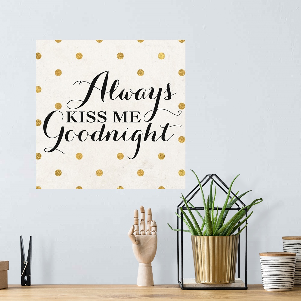 A bohemian room featuring The words "Always Kiss Me Goodnight" in black script on a cream background with gold dots.