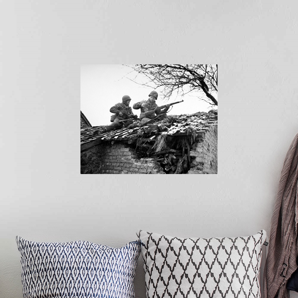 A bohemian room featuring American rifleman on a rooftop in Beffe, Belgium, snipe German snipers. Photographed 7 January 1945.
