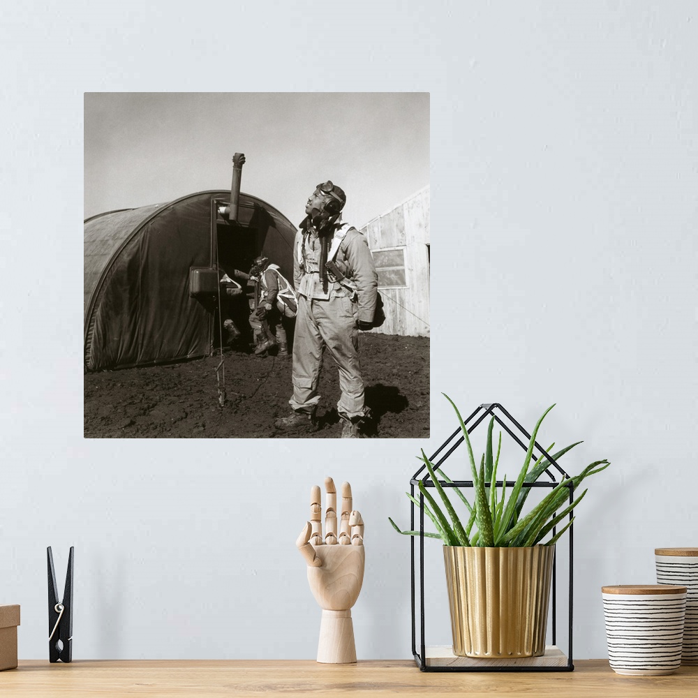 A bohemian room featuring Fighter pilot Newman Golden of the Tuskegee Airmen scans the skies. Behind him is the parachute r...