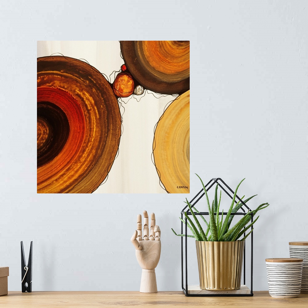 A bohemian room featuring Abstract painting with a geometric circle designs in red, yellow, and orange tones on a faded cre...