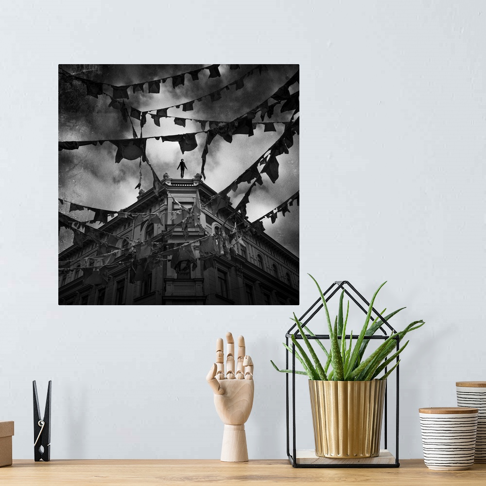 A bohemian room featuring Conceptual image of young adult male falling from tall building with clothes hung from bunting ac...
