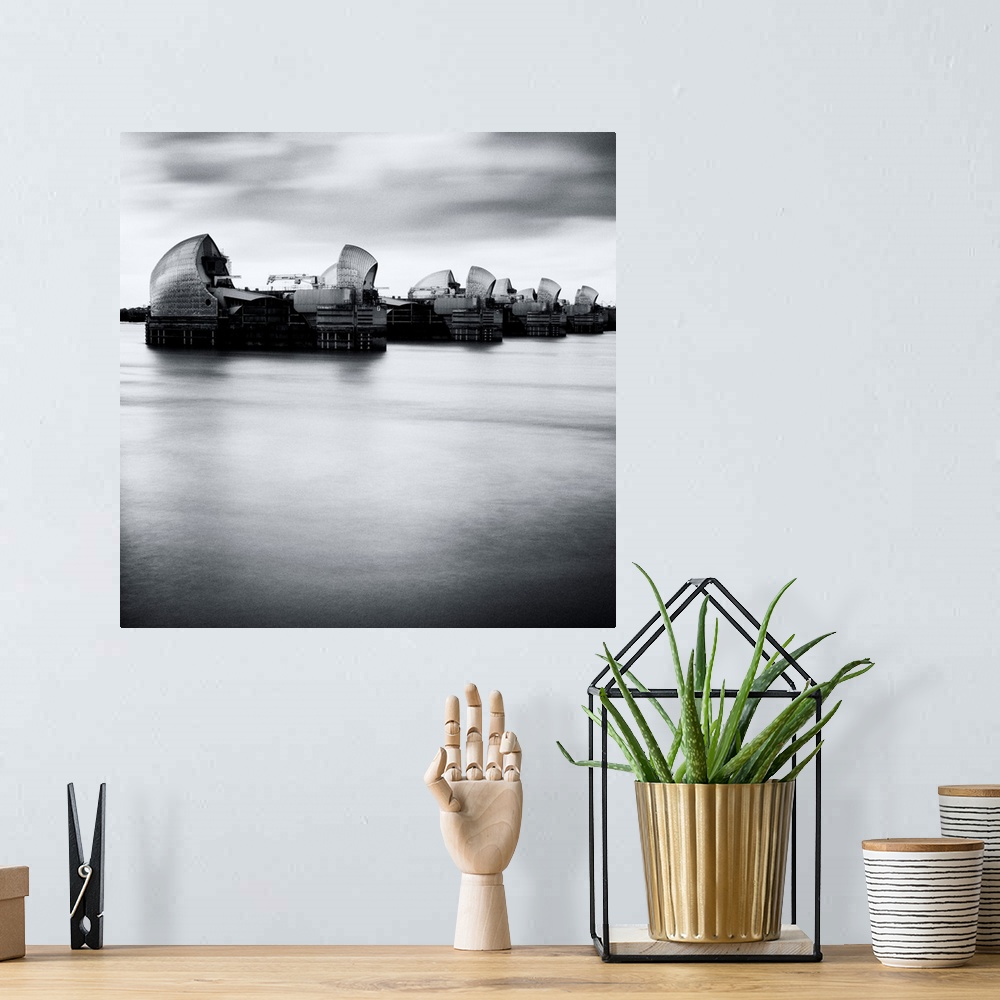A bohemian room featuring Thames Barrier, london with Canary Wharf in background under grey sky