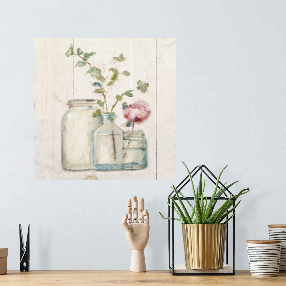 A bohemian room featuring Square artwork with flowers and branches in glass vases on a rustic shiplap background.