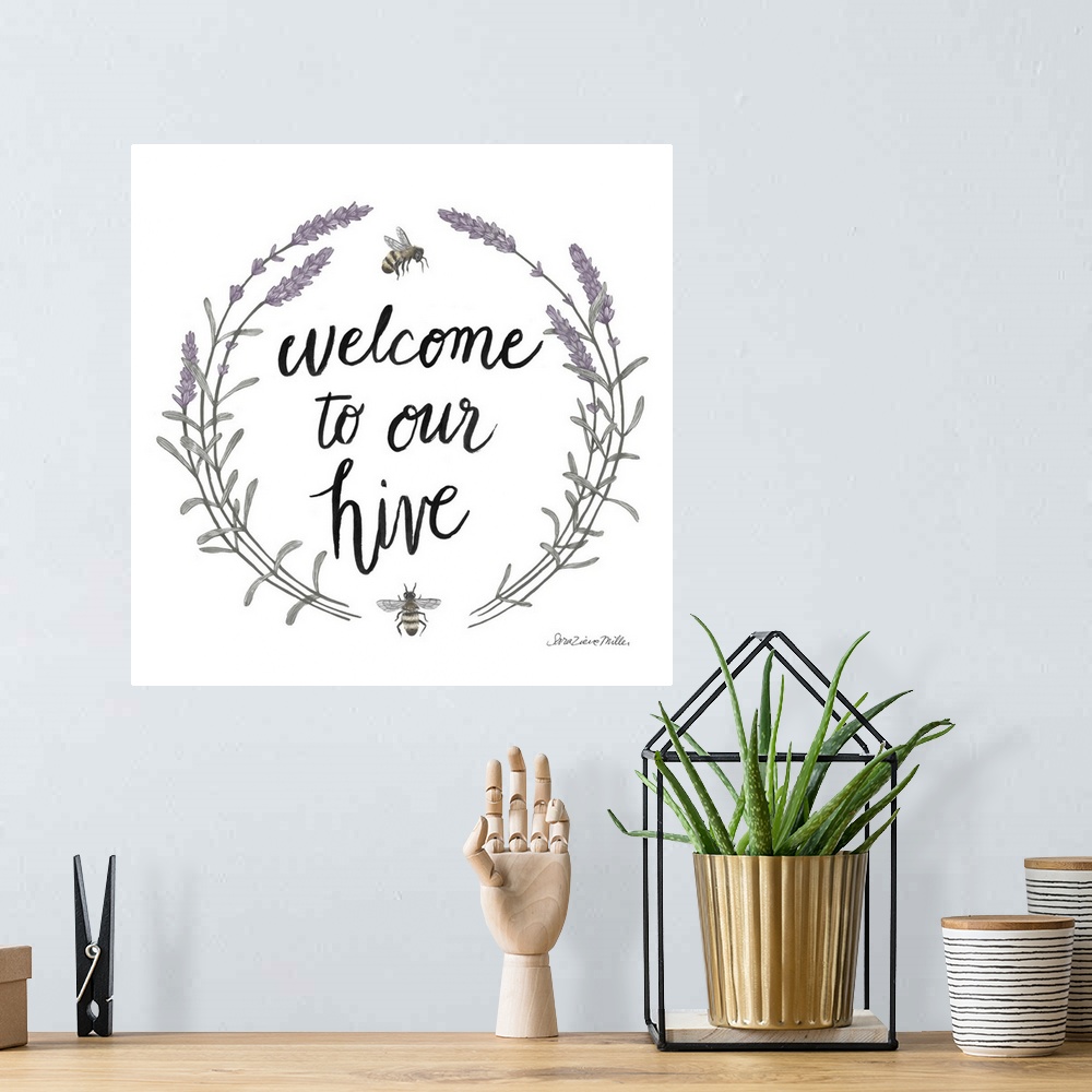A bohemian room featuring "Welcome To Our Hive" framed with a wreath of purple flowers and bees.