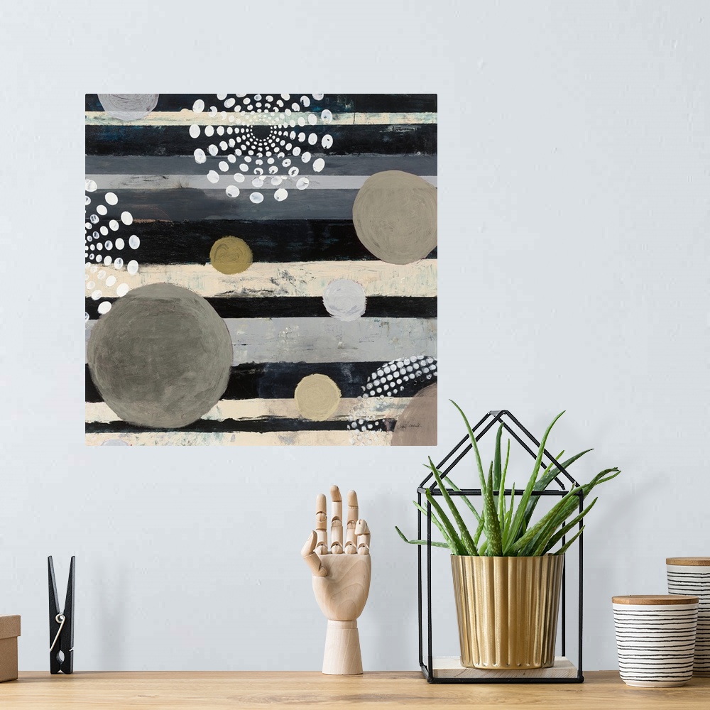 A bohemian room featuring Square abstract art with a striped background and different colored circles on top.