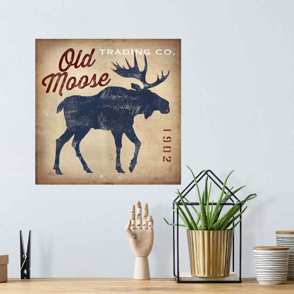 A bohemian room featuring Retro style sign for Old Moose Trading Company, with a blue moose silhouette.