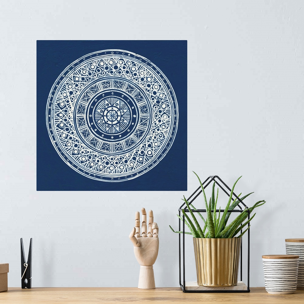 A bohemian room featuring Square abstract art with a white symmetrically designed mandala on an indigo background.