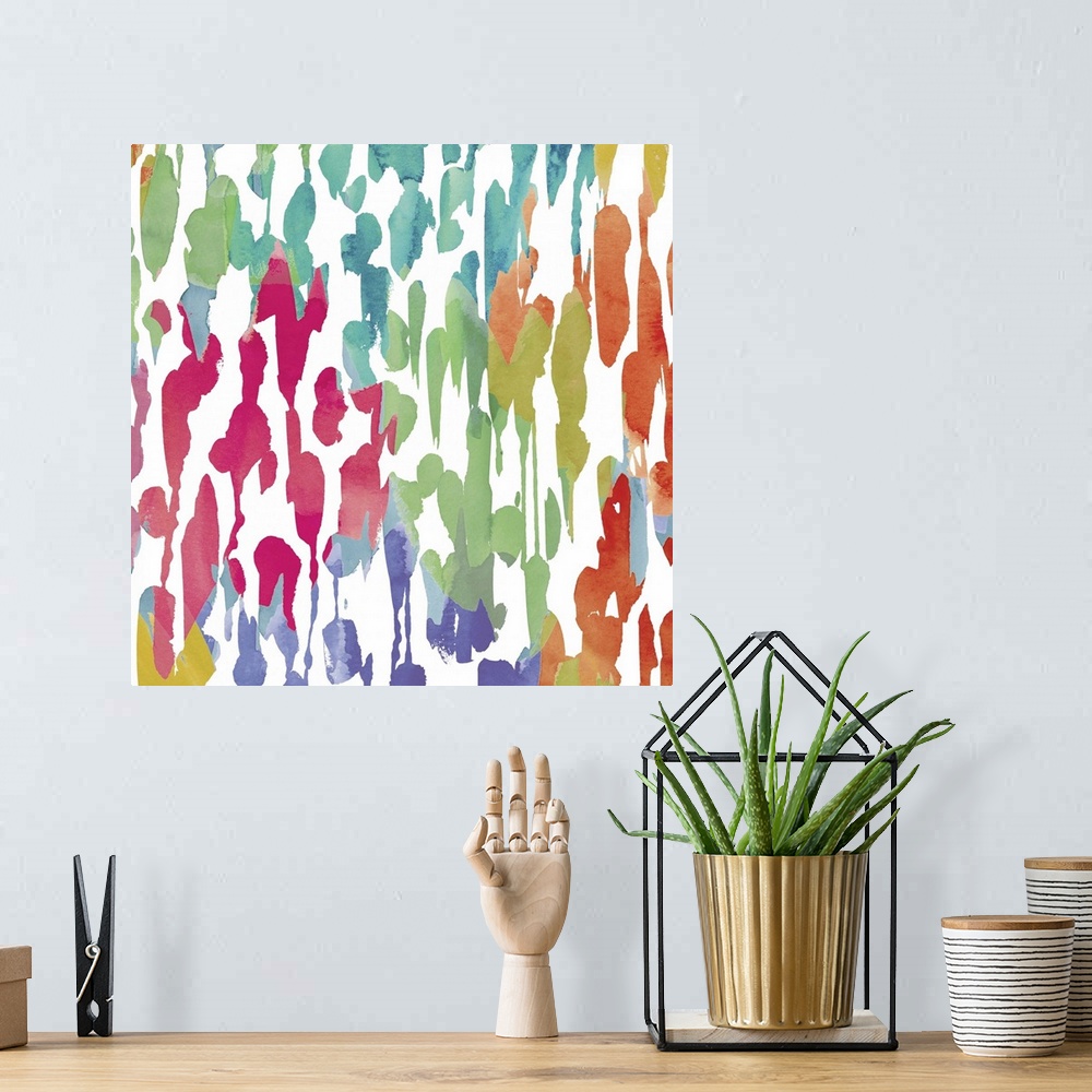 A bohemian room featuring Bright artwork made of varying splatters in rainbow colors.