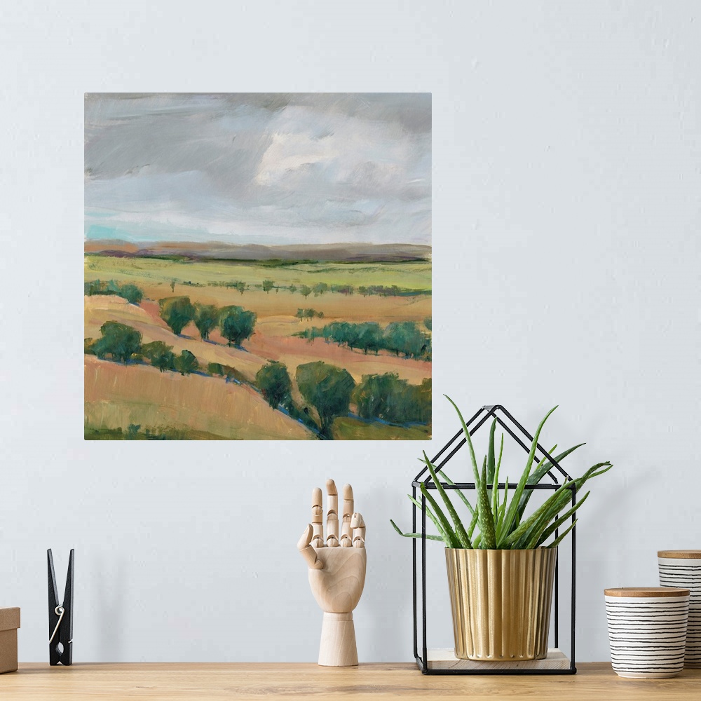 A bohemian room featuring Contemporary landscape painting of hills dotted with trees under a cloudy sky.