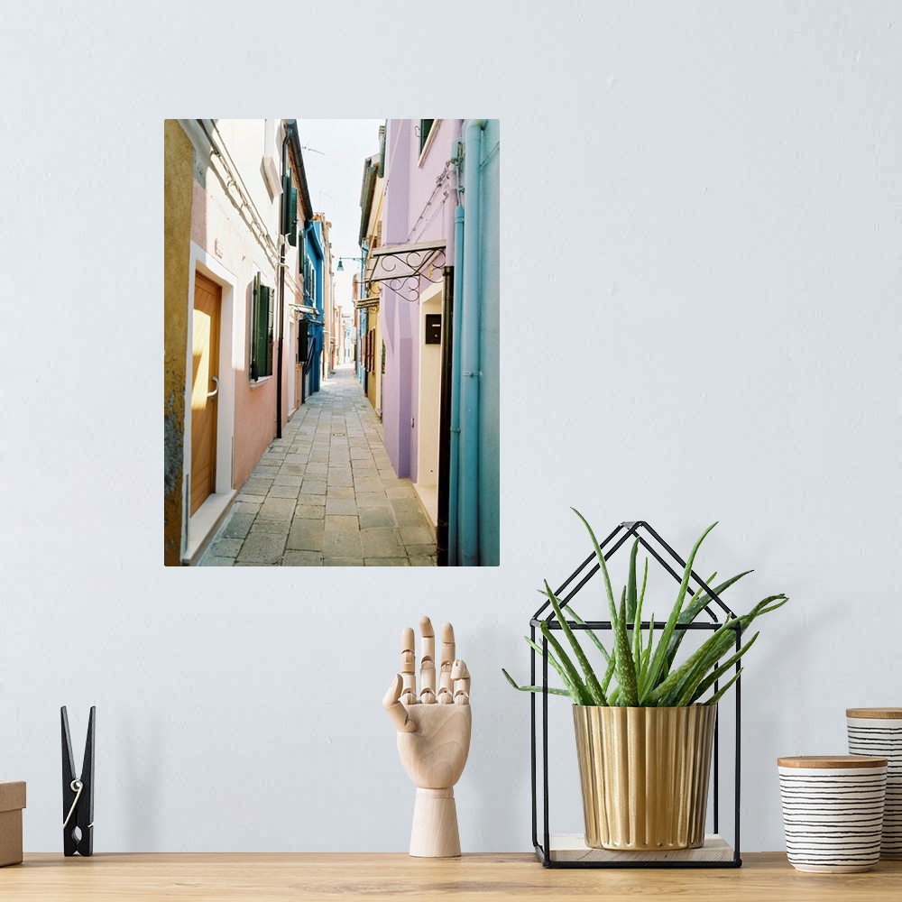A bohemian room featuring Photograph of brightly painted houses in a narrow alleyway, Burano, Italy.