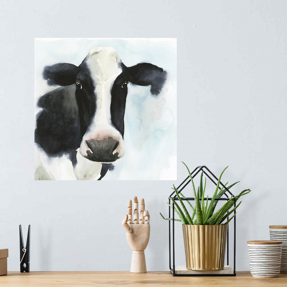 A bohemian room featuring A watercolor portrait of a black and white cow with pink and blue accents.