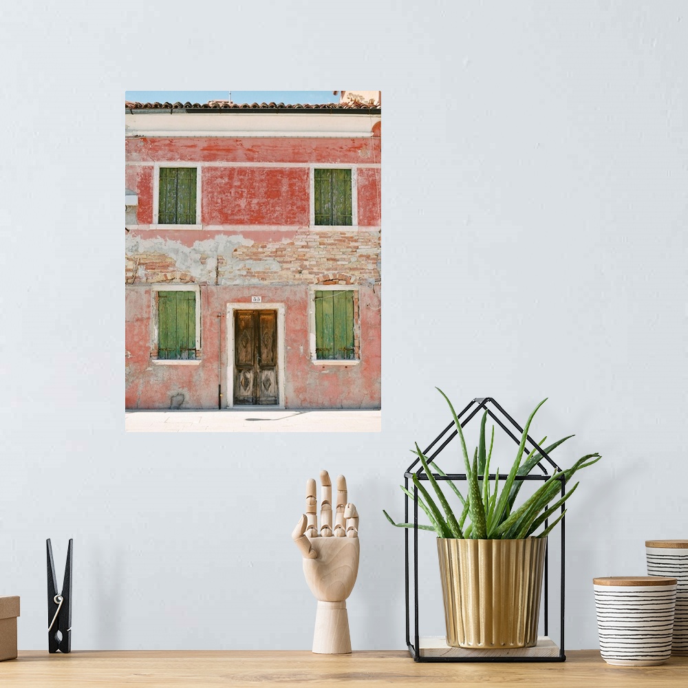 A bohemian room featuring Photograph of a very old building with green shutters and pink walls, Burano, Italy.