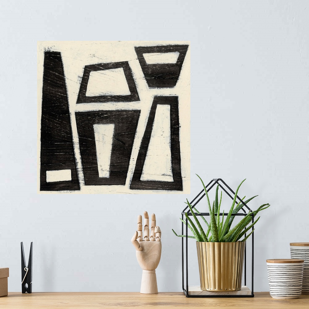 A bohemian room featuring Black and white abstract artwork made of trapezoids.