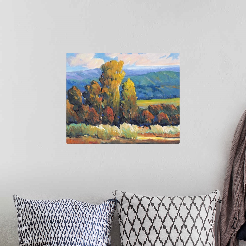 A bohemian room featuring Contemporary painting of a mountain valley landscape with a grove of trees in the fall.