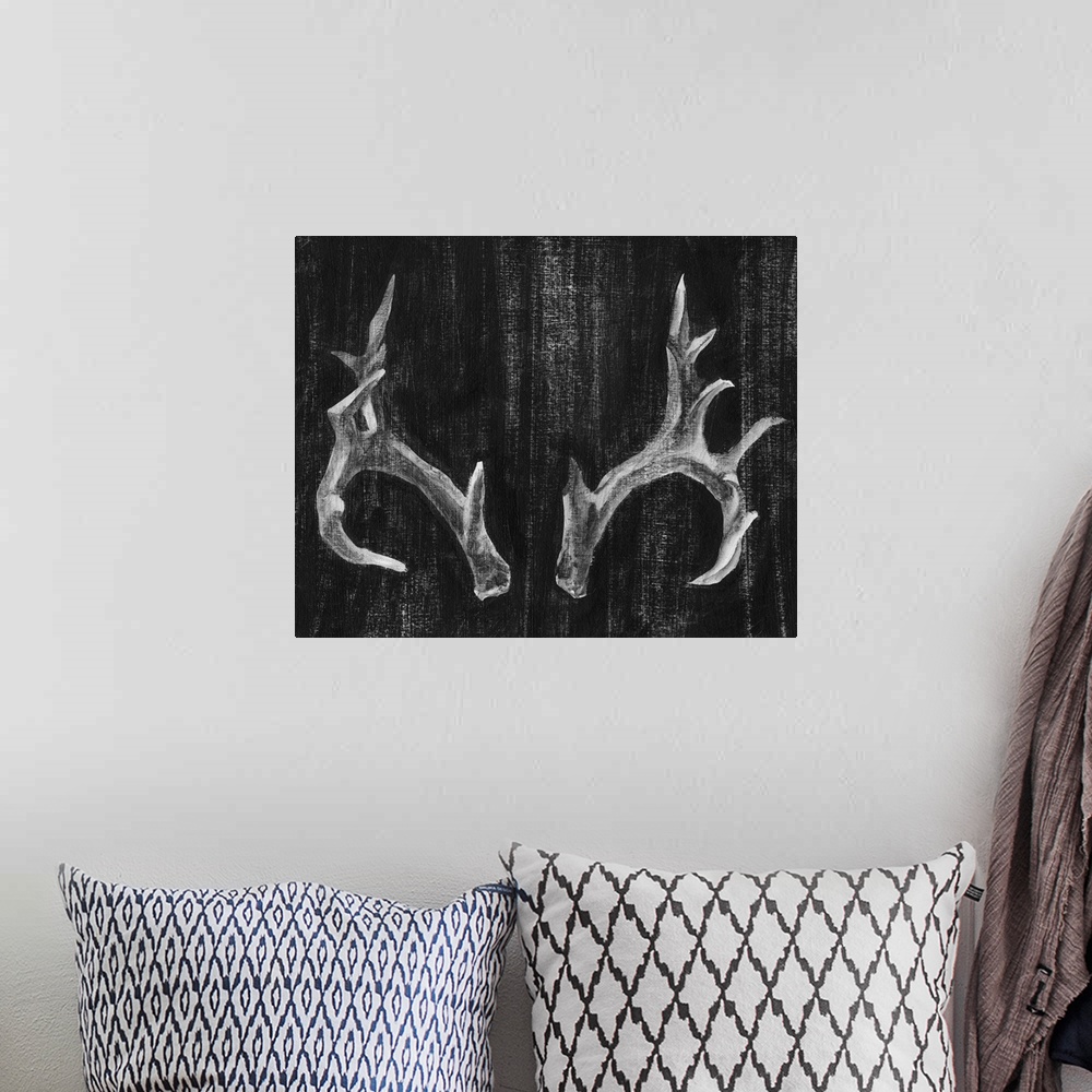A bohemian room featuring Contemporary artwork of a set of large pronged antlers.